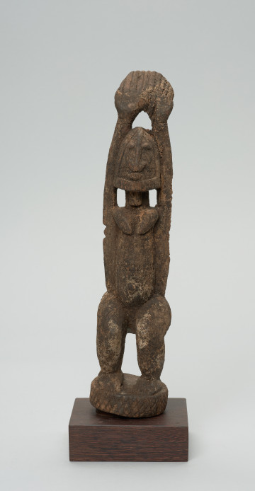 rzeźba - Ujęcie z przodu. Figura - postać kobiety stojącej z wyciągniętymi do góry rękoma.