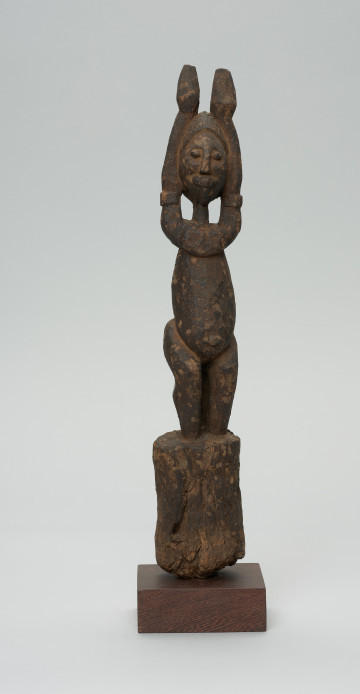 rzeźba - Ujęcie z przodu. Figura - postać przodka. Figura przedstawia postać kobieta z uniesionymi do góry rękoma.