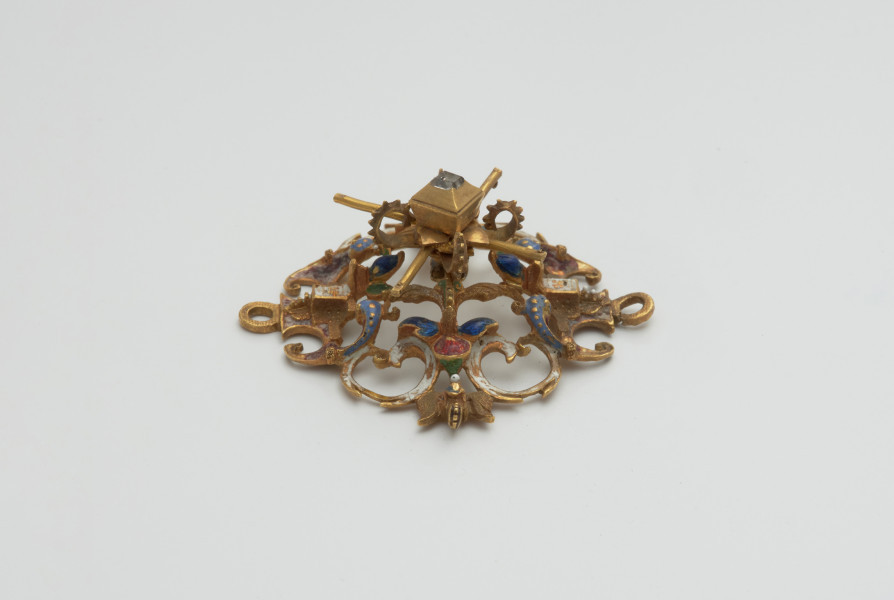 biżuteria, ozdoby - Ujęcie w pionie lewej strony. Ażurowy klejnot z kołpaka z diamentem i - pierwotnie -czterema perłami, zdobiony barwną emalią.