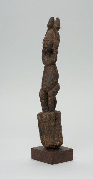 rzeźba - Ujęcie z przodu z lewej strony. Figura - postać przodka. Figura przedstawia postać kobieta z uniesionymi do góry rękoma.
