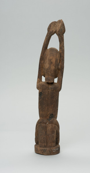 rzeźba - Ujęcie z tyłu; Kobieta przedstawiona w pozycji klęczącej z rękoma uniesionymi do góry. Włosy sięgające wysokości ramion. Widoczna spodnia strona stóp.