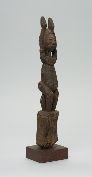 rzeźba - Ujęcie z przodu z prawej strony. Figura - postać przodka. Figura przedstawia postać kobieta z uniesionymi do góry rękoma.