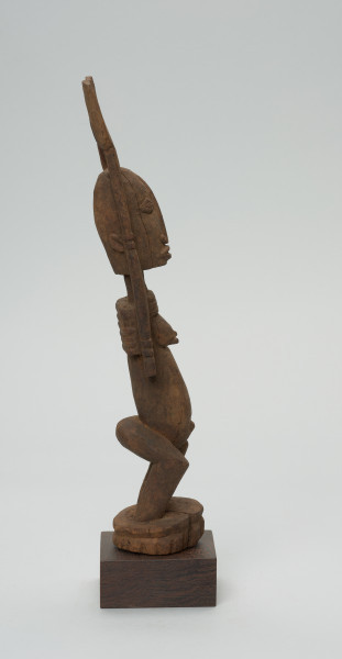 rzeźba - Ujęcie prawego boku. Figura przedstawiajaąca postać kobiety z rękoma uniesionymi do góry. Ręce są nie proporcjonalnie długie.