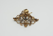 biżuteria, ozdoby - Ujęcie w pionie przodu klejnotu. Ażurowy klejnot z kołpaka, perwotnie z diamentem i czterema perłami, zdobiony barwną emalią.