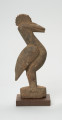 rzeźba - Ujęcie lewej strony. Figurka ptaka calao (dzioborożec) wykonana z drewna. Ptak stoi na dwóch nogach, wyprostowany, charakteryzuje się dużym dziobem i czubem na głowie.
