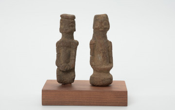 rzeźba - Ujęcie z przodu; Zestaw składa się z dwóch małych, drewnianych figurek przedstawiających postacie ludzkie w pozycji stojącej. Rzeźby o uproszczonej formie i masywnej budowie ciała.