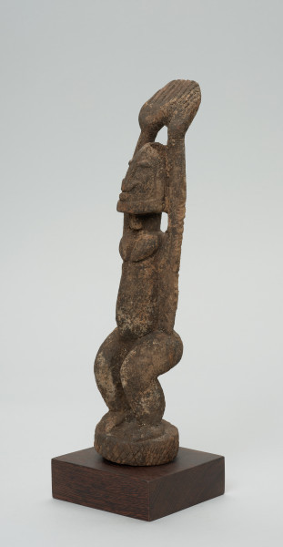 Ujęcie z przodu z lewej strony. Figura - postać kobiety stojącej z wyciągniętymi do góry rękoma.