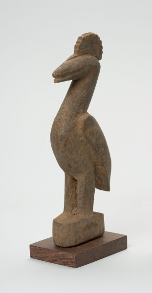 rzeźba - Ujęcie przodu skosem w lewą stronę. Figurka ptaka calao (dzioborożec) wykonana z drewna. Ptak stoi na dwóch nogach, wyprostowany, charakteryzuje się dużym dziobem i czubem na głowie.