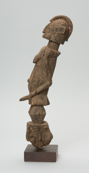 rzeźba - Ujęcie lewego boku. Figura przedstawiająca postać przodka łączącego w sobie cechy obu płci. Wyraźnie zaznaczone są piersi kobiece oraz penis - co rzadko spotyka się w sztuce dogońskiej.