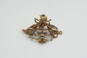 biżuteria, ozdoby - Ujęcie w pionie lewej strony klejnotu. Ażurowy klejnot z kołpaka, perwotnie z diamentem i czterema perłami, zdobiony barwną emalią.