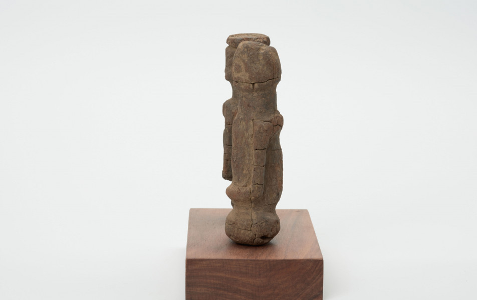 rzeźba - Ujęcie z drugiego boku; Zestaw składa się z dwóch małych, drewnianych figurek przedstawiających postacie ludzkie w pozycji stojącej. Rzeźby o uproszczonej formie i masywnej budowie ciała.