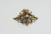 biżuteria, ozdoby - Ujęcie z boku od góry. Ażurowy klejnot z kołpaka z diamentem i czterema perłami, zdobiony barwną emalią.