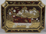 zbliżenie na inkrustowaną dekorację wieka - scena z Amorkami, widok z góry. Scena Toaleta Wenus, krawędzie wieka pokryte dekoracjami z brązu w postaci palmet i ornamentu kwiatowego.