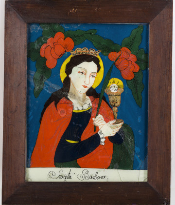 Obraz przedstawiający św. Barbarę z kielichem w prawej, a rózgą w lewej dłoni. Kolory: niebieski, czerwony, zielony, brązowy i złoty. Oprawny w gładkie drewniane ramy. Malowany farbami olejnymi na odwrocie szkła.

