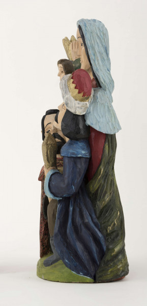 Rzeźba z drewna lipowego, technika strugania, polichromowana farbami plakatowymi. Na postumencie w kształcie nieregularnego owalu o wym. 23 x 13 x 1,5 cm, w kolorze seledynowym, zakomponowane zostały cztery postacie. W głębi z lewej strony postać króla (wys. 38 cm) w granatowej długiej szacie i zielonym płaszczu, z okrągłym kołnierzem. Król w lewej podniesionej ręce trzyma złotą koroną, w prawej – srebrny dzbanek. Z prawej strony postać Matki Boskiej (wys. 38,5 cm) z Dzieciątkiem (wys. 17 cm) w kremowej sukience, na prawym ręku. MB w czerwonej długiej sukni, zielonym płaszczu i niebieskiej chustce na głowie. Przed MB z lewej strony klęczy król (wys. 24,5 cm) w czerwonym płaszczu i czarnej sukni, który w rękach trzyma złotą szkatułkę. Z prawej strony klęczy król (wys. 28,5 cm) w granatowym płaszczu o niebieskim podbiciu i mankietach, brązowych spodniach, granatowych butach sięgających do połowy łydki. Na głowie ma złotą koronę na czerwonej czapce, otoczonej białym zawojem. W lewej ręce trzyma złotu kielich. 