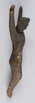 E/5175/ML - Rzeźba drewniana przedstawiająca Chrystusa Ukrzyżowanego. Głowa lekko pochylona. Twarz potraktowana schematycznie. Korona cierniowa w postaci opaski zdobionej rytem ukośnych rombów. Ręce łukowato wygięte ku górze, słabo zaznaczona klatka piersiowa, biodra silnie wystające, nogi lekko zgięte w kolanach, stopy słabo zaznaczone. Drewno prawdopodobnie lipowe. Figurka pęknięta wzdłuż. Brak krzyża.