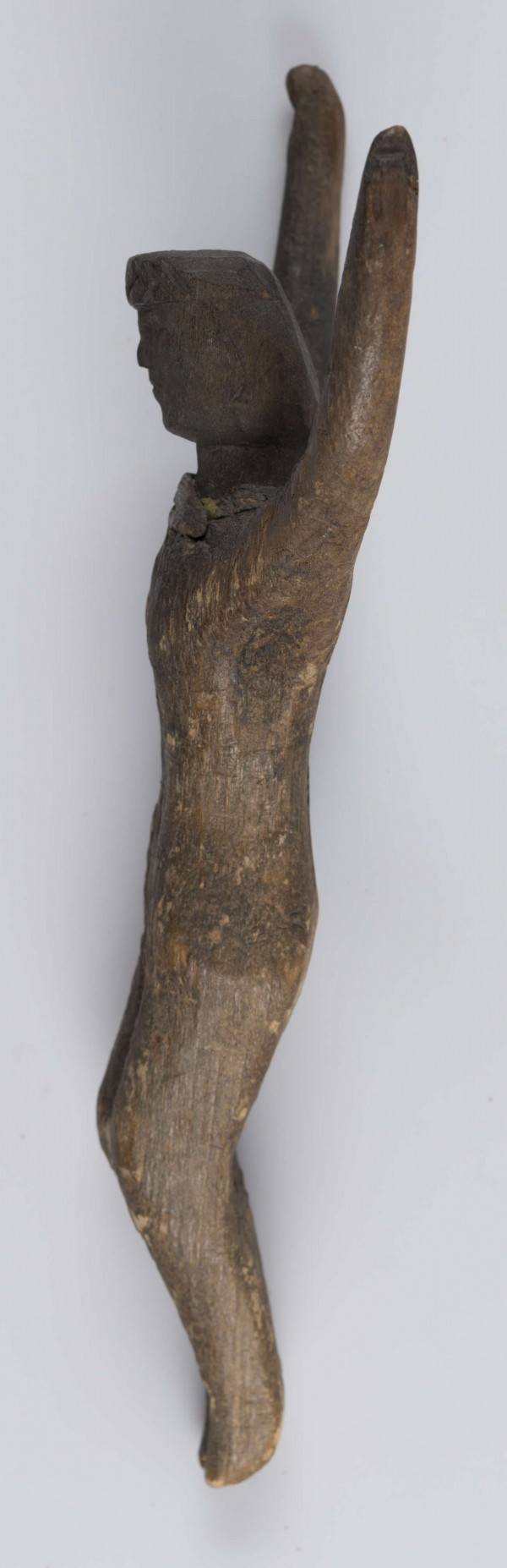 E/5175/ML - Rzeźba drewniana przedstawiająca Chrystusa Ukrzyżowanego. Głowa lekko pochylona. Twarz potraktowana schematycznie. Korona cierniowa w postaci opaski zdobionej rytem ukośnych rombów. Ręce łukowato wygięte ku górze, słabo zaznaczona klatka piersiowa, biodra silnie wystające, nogi lekko zgięte w kolanach, stopy słabo zaznaczone. Drewno prawdopodobnie lipowe. Figurka pęknięta wzdłuż. Brak krzyża.