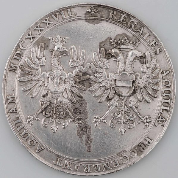 N/1242/ML - AV. W tondzie ujetym profilowym otokiem Hercules poskramia ujarzmionego Cerbera. W tle kosciół. Z prawej litery I H, monogram autora medalu. Niżej, w odcinku, kartusz z herbem miasta rozdziela napis:
CIVIT - GEDAN / F . - F .
w otoku napis rozpoczynający się od arabeski:
VLADISLAO IV POLONIAE ET SVECIAE REGI HERCULI PACIFICO

RV. W tondzie ujętym profilowanym otokiem dwa ukoronowane orły. Z lewej polski ze Snopkiem Wazów, z prawej dwugłowy z herbem Habsburgów na piersiach. W otoku napis poprzedzony rozetką:
REGALES AQUILAE PROGENERANT AQUILAM . MDCXXXVII .
W miejscu kropek znaki międzywyrazowe w postaci rombów.

Wżery na RV. najprawdopodobniej będące pozostałością po zalaniu kwasem. Na AV. w obszarze legendy cechy bicia pękniętym stemplem.