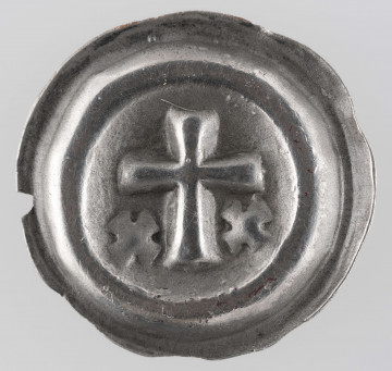 N/2940/ML - Krzyż łaciński o lekko rozszerzających się końcach ramion. Na dole, z obu stron dłuższego ramienia krzyża, krzyżyki ukośne.