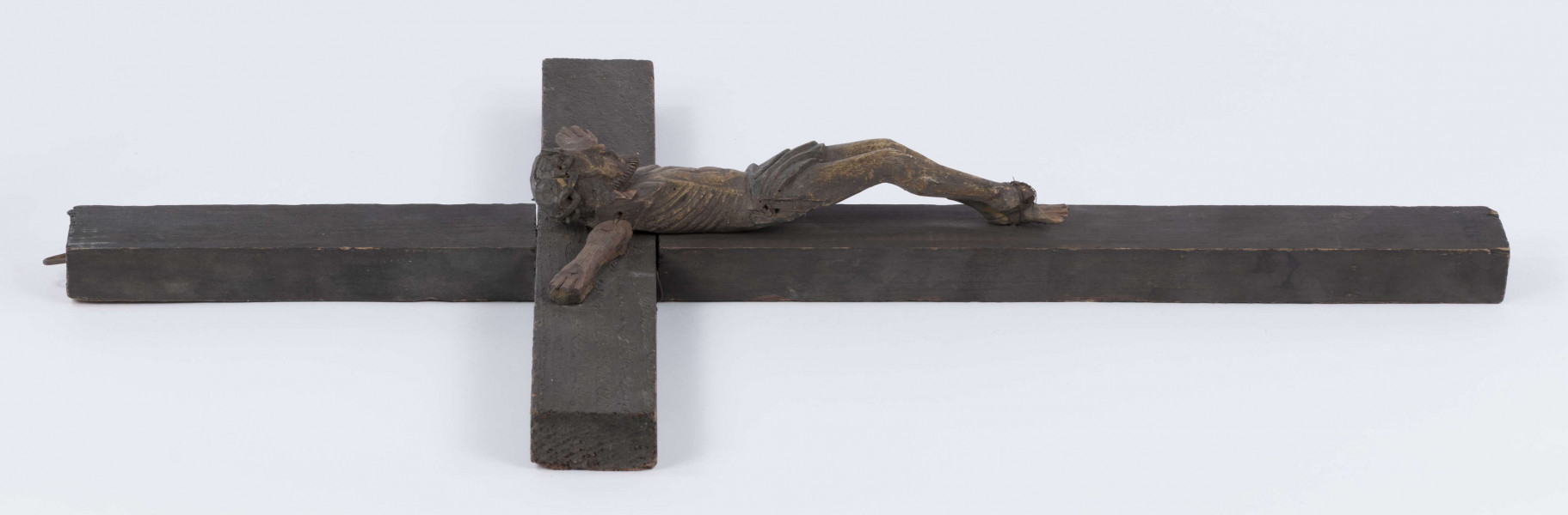 E/371/ML - Rzeźba w drewnie przedstawiająca Chrystusa Ukrzyżowanego na krzyżu sosnowym. Głowa w cierniowej koronie, schylona lekko w prawa stronę. Ciało nagie. Polichromowana, kolor brązowy. Ręce nieudolnie dorobione przez innego rzeźbiarza, z innego drewna. 