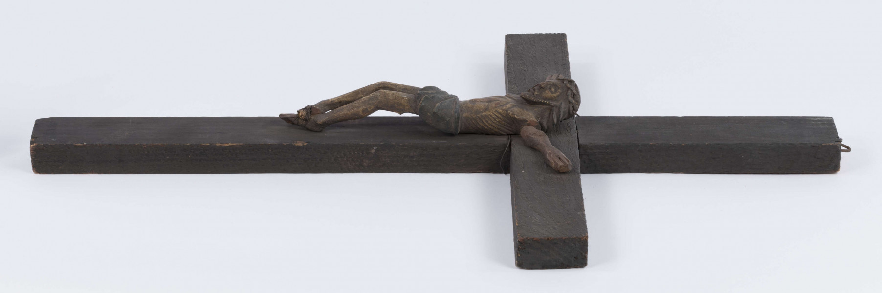 E/371/ML - Rzeźba w drewnie przedstawiająca Chrystusa Ukrzyżowanego na krzyżu sosnowym. Głowa w cierniowej koronie, schylona lekko w prawa stronę. Ciało nagie. Polichromowana, kolor brązowy. Ręce nieudolnie dorobione przez innego rzeźbiarza, z innego drewna. 