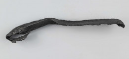 Żelazny grot oszczepu z ostrym żeberkiem środkowym, zgięty rytualnie. Grot stanowi element wyposażenia ciałopalnego pochówku złożonego prawdopodobnie w popielnicy. Odkrycia dokonano w 1959 roku przypadkowo w czasie prac rolnych. Oprócz trzech grotów, pochówkowi wojownika towarzyszyły: żelazne umbo, dwie ostrogi, tok brązowy (prawdopodobnie okucie drzewca oszczepu) a także żelazny miecz z miedziana inkrustacją wyobrażającą rzymskich bogów. Pochowany na terenie obecnej wsi Podlodów wojownik należał do elity wojskowej przedstawicieli kultury przeworskiej.