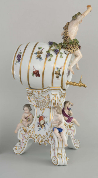 Grupa porcelanowa złoźona z dwóch elementów
1. beczka z siedzącym na niej Bachusem
2. podstawa zdobiona figurkami puttów