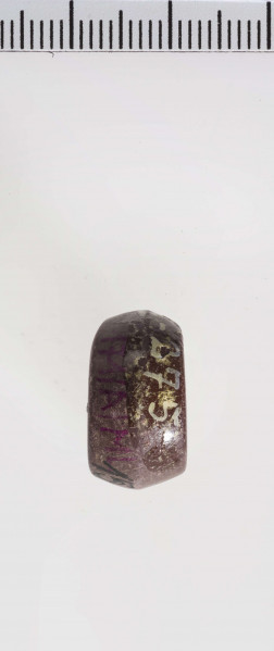 wykonany z łupka owruckiego; dwustożkowy, łagodnie profilowany; przy otworze płasko ścięty; otwór średniej wielkości, cylindryczny