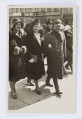 Fotografia przedstawia idących ulicą Jerzego Pola z żoną Zofią i córką Jadwigą. Mężczyzna w płaszczu wojskowym i czapce trzyma pod rękę kobietę, ubraną w długi czarny płaszcz z futerkowym kołnierzem oraz ciemne nakrycie głowy. W prawej ręce kobieta trzyma małą torebkę. Obok Zofii idzie Jadwiga ubrana w ciemny płaszcz wykończony futekiemm. Na głowie ma czarny kapelusz z małym rondem. W tle widoczni przechodnie oraz fasady kamienic. Fotografia obwiedziona białą ramką.