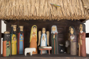 Szopka kolędnicza. Dach dwuspadowy. Na poszyciu dachu figurki trzech drewnianych kolorowych ptaszków. W szopce znajduje się 9 figurek drewnianych przedstawiających postaci ludzkie i żłóbek oraz figurki: osła, wołu i baranka. Pośrodku szopki stoi żłóbek z Dzieciątkiem, po lewej stronie postać Matki Boskiej (wys. 22 cm), po prawej – postać św. Józefa (wys. 22 cm). Za żłóbkiem z tyłu postać Anioła (wys. 21 cm). Przed żłóbkiem figurka przedstawiająca baranka. Z lewej strony wzdłuż ściany figurki trzech króli. Pierwszy król (wys. 16 cm) – murzyn, trzyma w rękach złotą kulę, drugi (wys. 21,5 cm) – złoty domek, trzeci (wys. 22 cm) – złotą księgę. Z prawej strony wzdłuż ściany znajdują się: mężczyzna (wys. 23 cm) w lewej ręce trzymający laskę, a w prawej worek, kobieta (wys. 21 cm) z kurą w rękach oraz – pomiędzy figurkami wołu i osiołka, postać mężczyzny grającego na trąbce. 
Figurki z drewna lipowego, polichromowane.