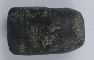 540/A/ML - Topór kamienny szlifowany i gładzony, barwy czarnej. Obuch niewyodrębniony. Otwór zlokalizowany bliżej obucha, nawiercony z obydwu stron.