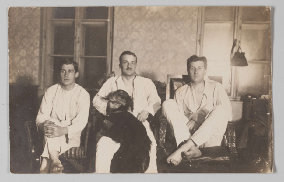 MPol/680/ML - Fotografia przedstawia siedzących obok siebie dwóch braci Żyborskich i Jerzego Pola - ich szwagra. Od lewej: na wiklinowym fotelu siedzi Wacław Żyborski z prawą nogą założoną na lewą i zaplecionymi na kolanie dłońmi; obok niego Jerzy Pol, trzymający na kolanach psa rasy seter szkocki (o imieniu 