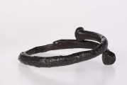 Bransoleta wykonana z żelaznego pręta o okrąłym przekroju. Jej zachodzące na siebie końce są ukształtowane w płaskokuliste guzy.