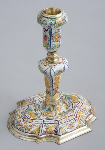 ujęcie 3/4. Ujęcie z góry, podstawa wypukła bogato zdobiona, na białym tle podzielona czerwoną cienką ramką na mniejsze sceny na skośnych elementach a w centralnej części trzon. Całość bogato zdobiona na białym tle złote postacie i kolorowe kwiaty i owoce.