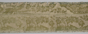 Pas tkaniny z motywami roślinnymi w kolorze żółto-zielonym. Na górze pas odbarwiony na niebiesko. Widoczny poziomy szew oraz trzy pionowe szwy sięgające od dołu do poziomego szwu. bryt Wil.Wn.132/1 - fragment, awers; ściana północna