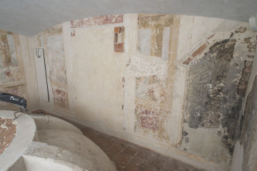 Malarska dekoracja ściany W 45M0015 bardzo słabo widoczna i mocno zniszczona, w lewym dolnym narożniku fragment półkolistej czaszy kopuły z widocznymi żebrami.