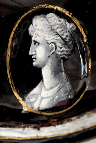 fragment wewnętrznej części pokrywy - medalion z głową antyczną kobiety zwróconej w lewo.