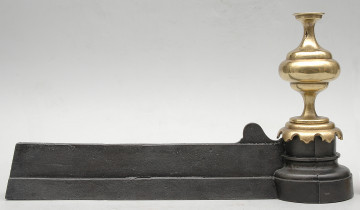 strona pierwsza. Czarna żelazna listwa zajmuje całą dolną część kadru. Po prawej stronie jest zakończona sterczyną z polerowanego, jasnożółtego metalu. Sterczyna jest toczona, okrągła w przekroju, z wyraźnymi przewężeniami u góry i u dołu.