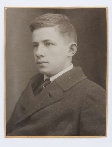Adam Żeromski w kurtce w białym kołnierzyku i krawacie. Włosy zaczesane na prawą stronę. Fotografia wykonana 1917 r. w Zakopanym do paszportu w czasie wyjazdu do Nałęczowa.