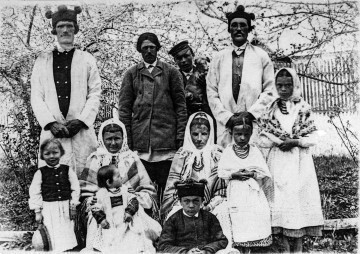 Fotografia czarno-biała przedstawia grupę jedenastu osób w strojach ludowych.