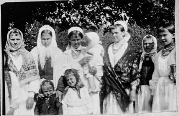 Fotografia czarrno-biała przedstawia grupę kobiet i dzieci ubranych w stroje ludowe.