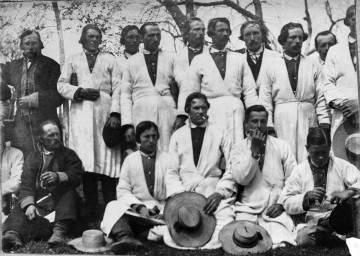 Fotografia czarno-biała przedstawia grupę mężczyzn: w pierwszym rzędzie siedzących, w drugim stojących.