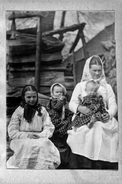 Fotografia czarno-biała przedstawia kobietę i troje dzieci ubranych w stroje ludowe.