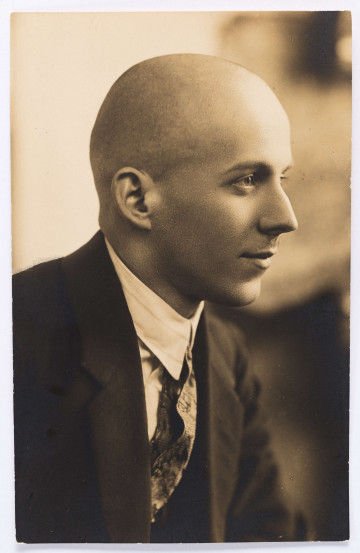 Fotografia portretowa czarno-biała Wacława Gralewskiego przedstawiająca jego prawy profil. Gralewski ubrany w ciemną marynarkę, białą koszulę i czarny krawat