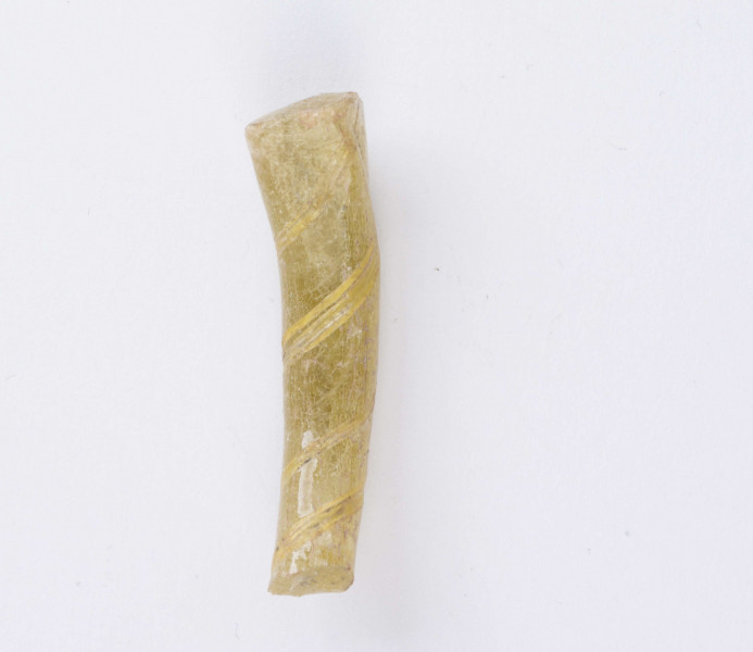 Fragment bransolety szklanej o okrągłym przekroju poprzecznym, miejscami spłaszczona. Wykonana ze szkła o kolorze żółtym z ornamentem spiralnie owijającego paska.