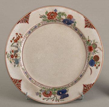 Talerz płytki, zdobiony motywem roślinnym, kwiatowym i geometrycznym w kolorze zielonym, czerwonym, niebieskim i złotym