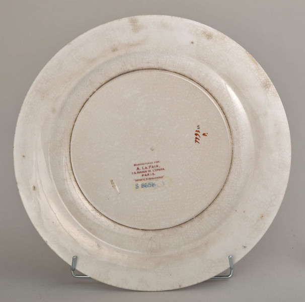 Talerz płytki, zdobiony motywem roślinnym, kwiatowym i geometrycznym w kolorze zielonym, czerwonym, niebieskim i złotym. Spód