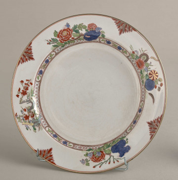 Talerz płytki, zdobiony motywem roślinnym, kwiatowym i geometrycznym w kolorze zielonym, czerwonym, niebieskim i złotym