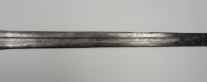 Miecz jednoręczny typu XII (Oakeshott) - ujęcie 3/4; Na zbroczu krzyż wpisany w okrąg, powtórzony 4 razy pomiędzy krzyżami napisy ryte i wypełnione srebrnym metalem. Płaszczyzna A: NRCDISIC + EnSNRCH + NRCDISDV['A'] + ERCDISIA;