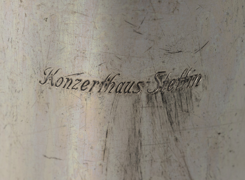 Dzbanuszek z zastawy Konzerthaus Stettin - detal; Widok centralnej części dzbanuszka. Na korpusie grawerowany napis: Konzerthaus Stettin.